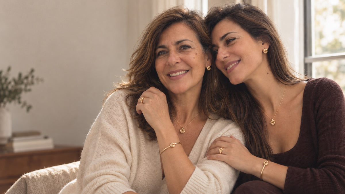 A Ana e a Alice, mãe e filha, sentadas no sofá, com o mesmo colar, os mesmos brincos e a mesma pulseira dourados.